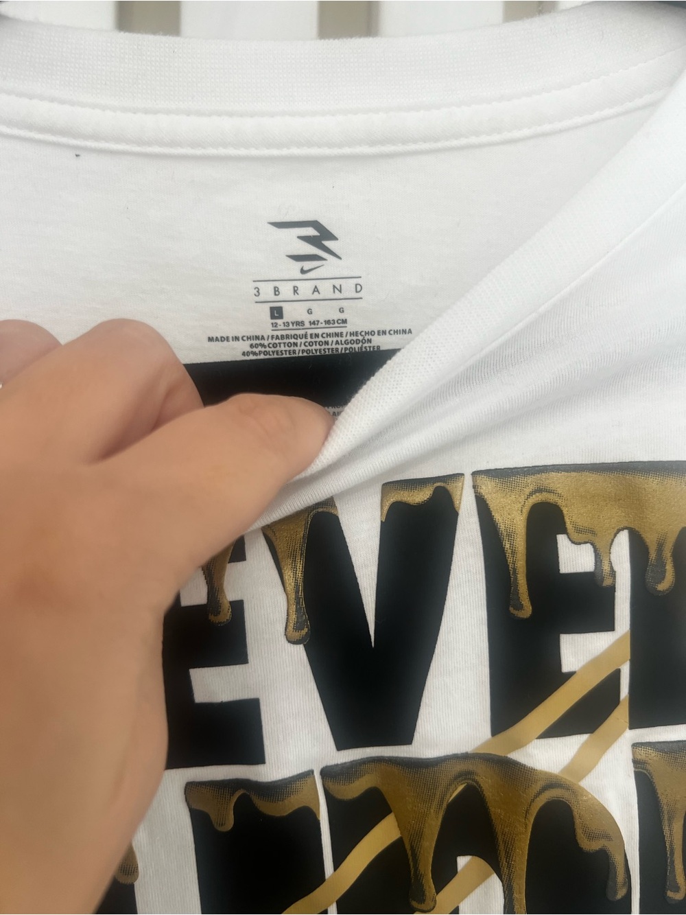 Nike Kids White Long Sleeve Tee with Black & Gold Drip Graphic